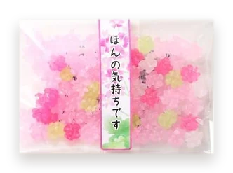 A small bag of konpeito sugar candy with a band printed ほんの気持ちです (brand photo).